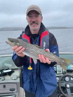 Man holding a Brown Trout he caught with Six Fins Guide Service.