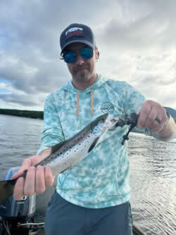 Man holding a Salman he caught with Six Fins Guide Service.