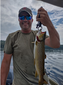 Man holding a Brown Trout he caught with Six Fins Guide Service.