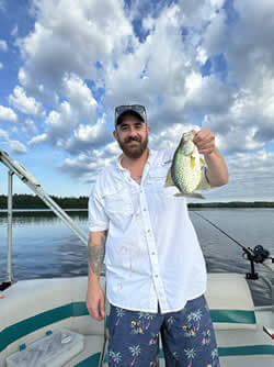 Man holding a Crappie he caught with Six Fins Guide Service.