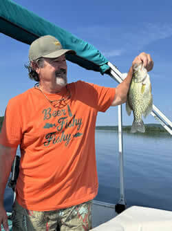 Man holding a Crappie he caught with Six Fins Guide Service.