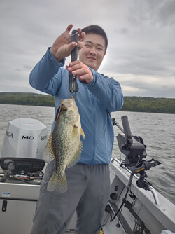 Man holding a Crappie he caught with Six Fins Guide Service.